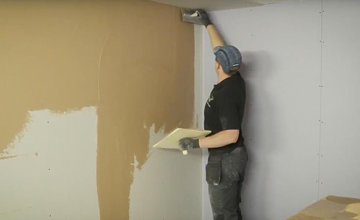 Нанесення фінішної шпаклівки шпателем на стіну перед фарбуванням
